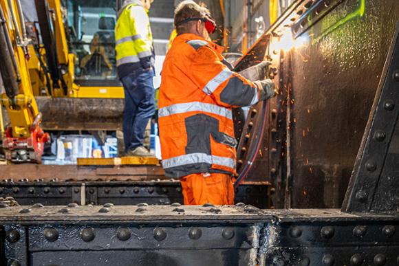 Arbeiter zerschneiden das Tragwerk aus Stahl